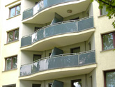 Apartamentowiec w Krakowie przy ul. Smoczej - przegrody balkonowe i balustrady wypełnione szkłem grafitowym.