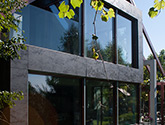 Realizacja domu jednorodzinnego. Zakres prac Wido-Profil - elewacja ze spieku kwarcowego, stolarka aluminiowa, balustrada całoszklana, elementy małej architektury - pergola oraz donice ogrodowe.