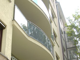 Apartamentowiec w Krakowie przy ul. Smoczej - przegrody balkonowe i balustrady wypełnione szkłem grafitowym.