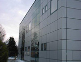 Budynek biurowy w Żabnie - fasada wykonana z płyty HPL łączy się z fasadą strukturalną oraz pozostałymi elementami stolarki aluminiowej.